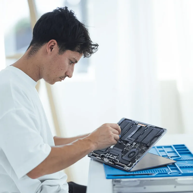 Technicien expert Apple réparant un MacBook à domicile à Genève